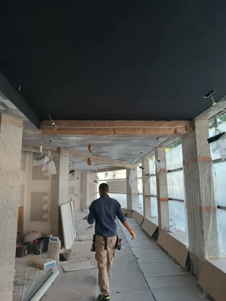 Hombre por empezar a pintar en pasillo con techo oscuro